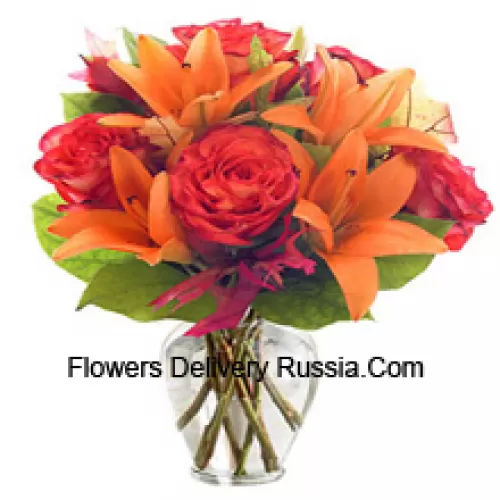 Orange Lilies And Orange Roses With Seasonal Fillers Arranged Beautifully In A Glass Vase