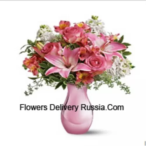Roses roses, lys roses et diverses fleurs blanches avec des fougères dans un vase en verre