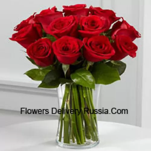11 rosas rojas con algunos helechos en un jarrón